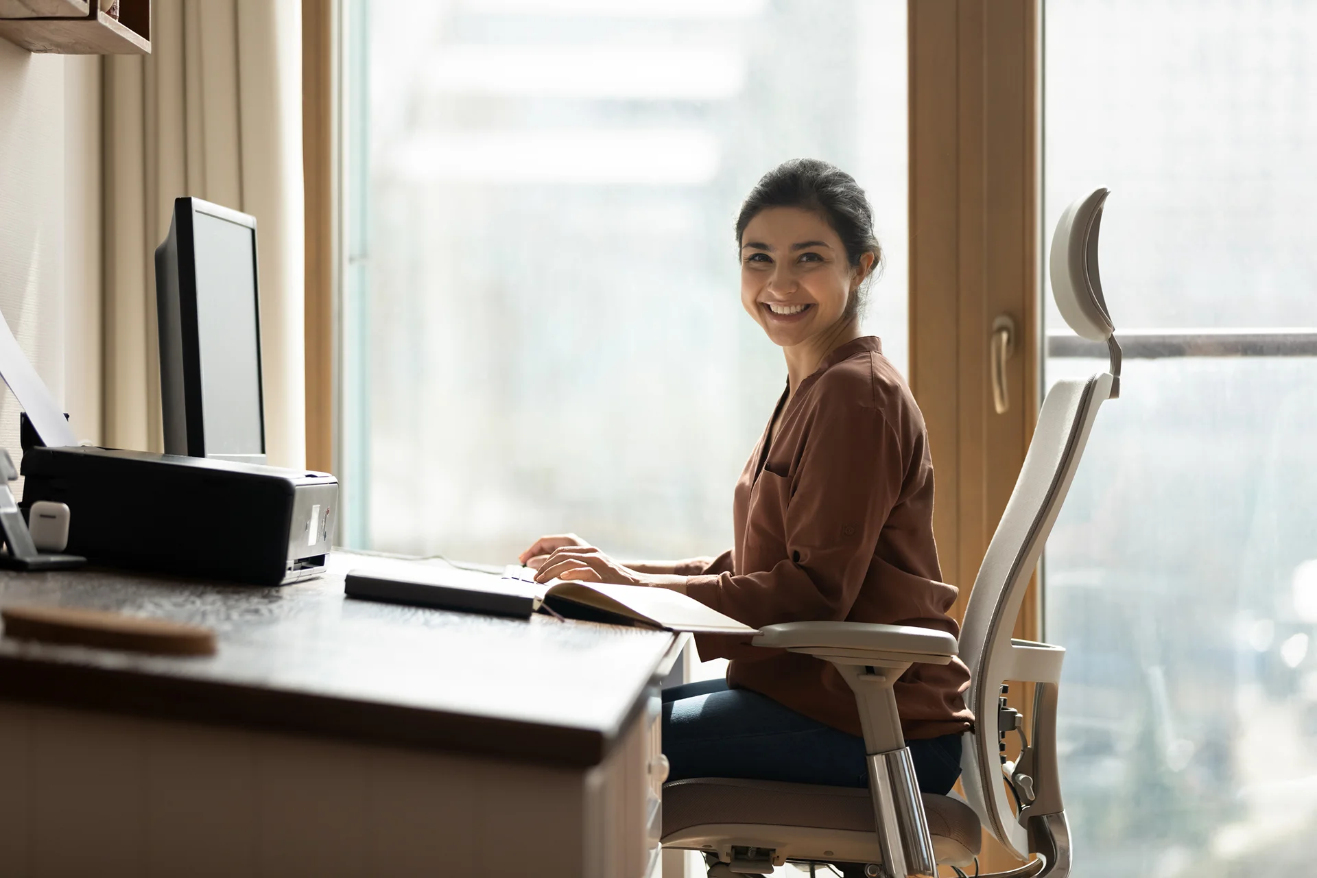woman sits on her ergonomic chair while working