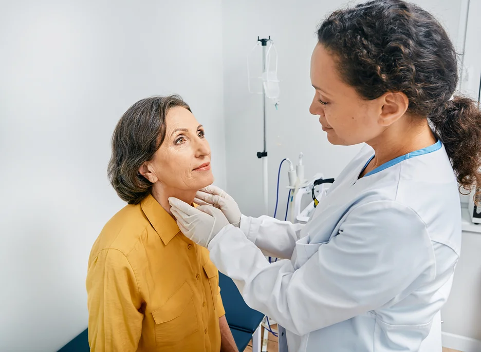 doctor examines the patient's neck