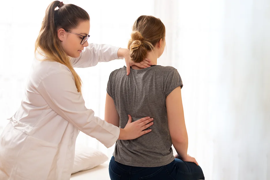 a doctor checks the patient's back pain problems