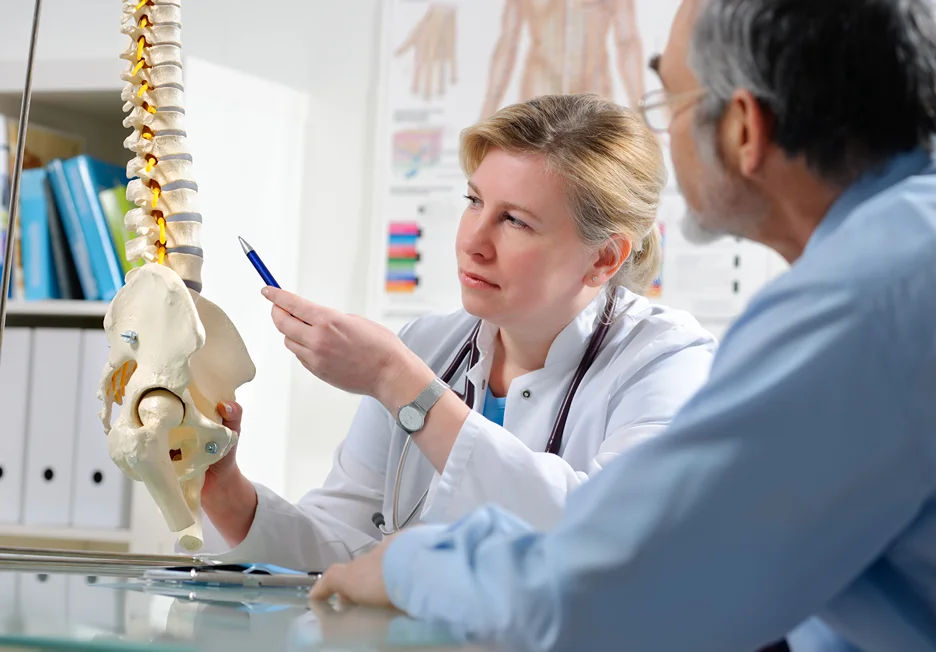 a doctor explains the nature of back pain problems to her patient