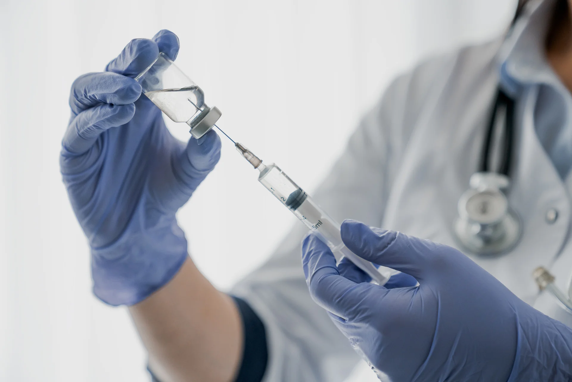 doctor holding a vial and syringe