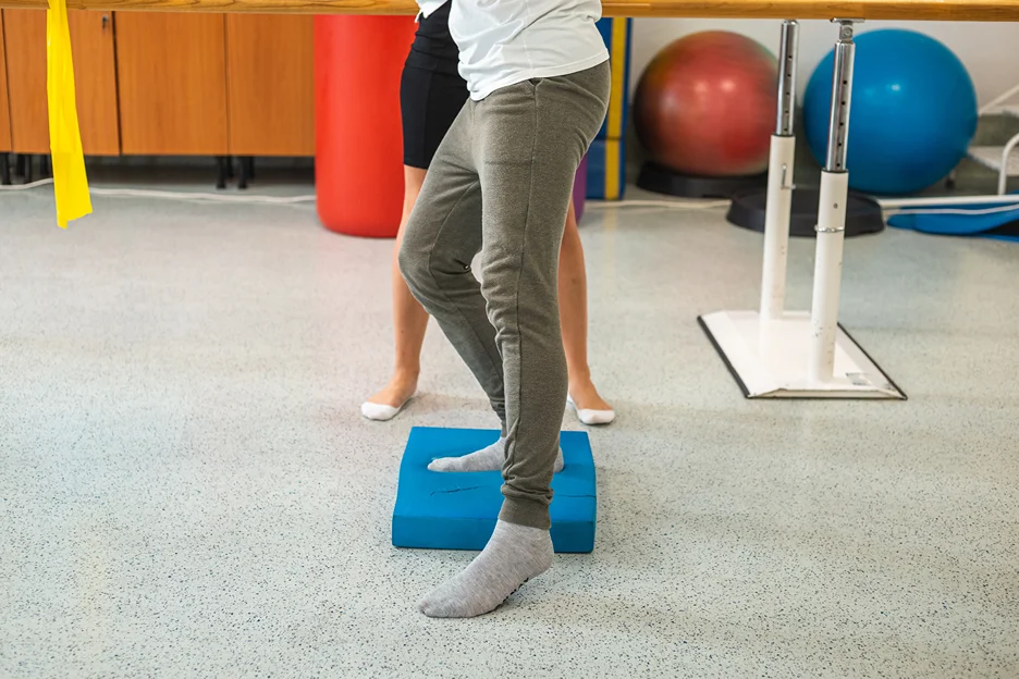 man tries balancing pad at a physical therapy clinic