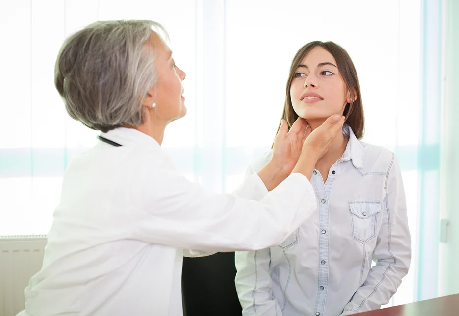 doctor examines the patient's neck