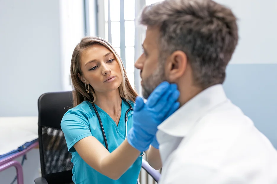 female doctor examines the patient's neck