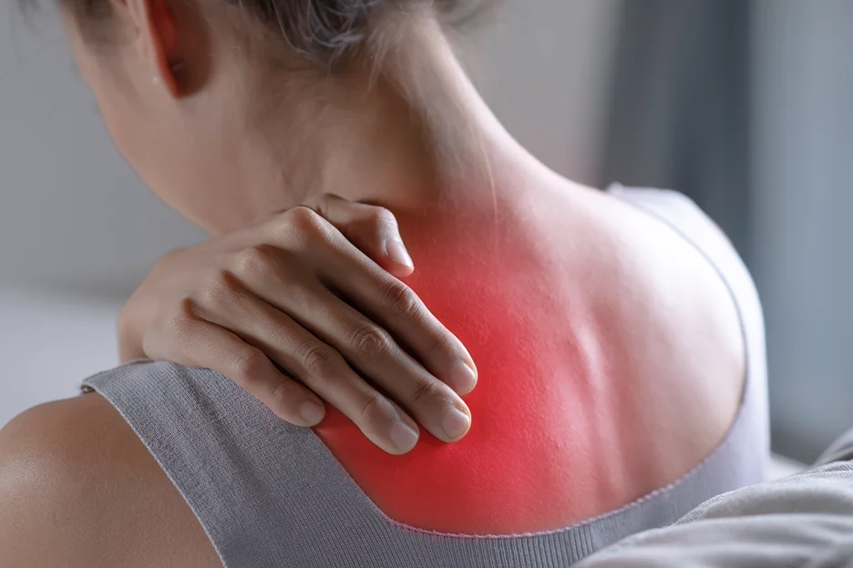 a woman suffers from persistent back pain between shoulder blades