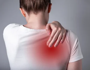 a woman suffers from back pain between shoulder blades