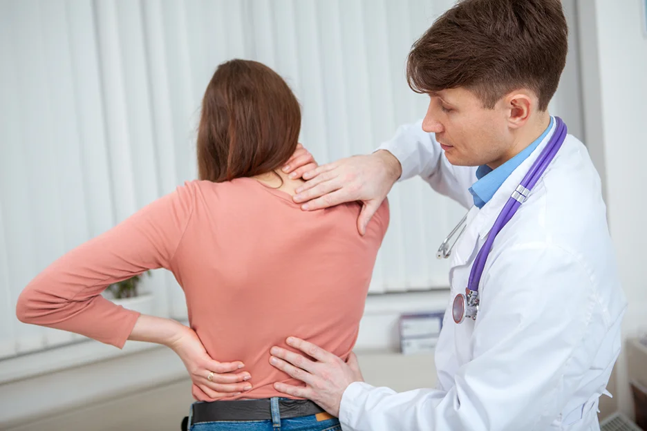 doctor examines his patient suffering from lower back pain