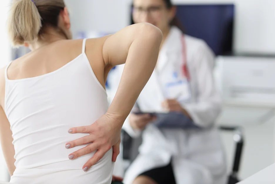 a woman complains to her doctor about rib and back pain