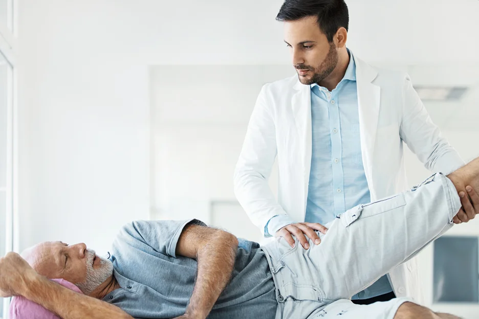 doctor examines the patient's lower back and hip pain