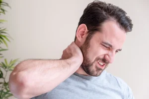 a man suffers sharp neck pain