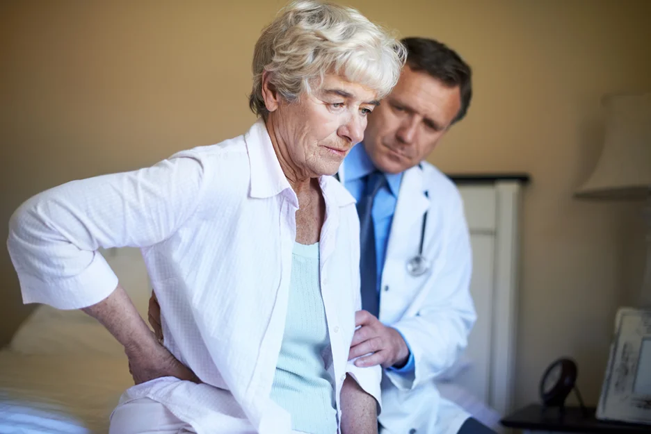 an elderly woman consults her doctor concerning low back pain