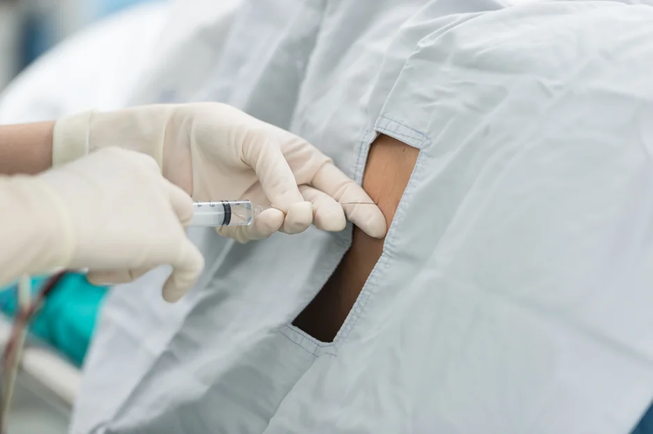 a doctor injects epidural on the patient's back