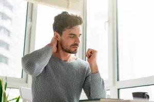 a man suffering from persistent neck pain