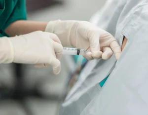 a doctor administers epidural injection on the patient for back pain relief