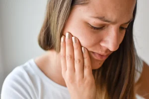 a woman suffers from neck and jaw pain