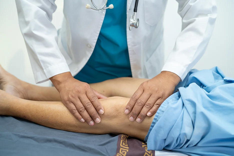 a doctor examines the patient's legs after suffering from sciatica muscle spasms