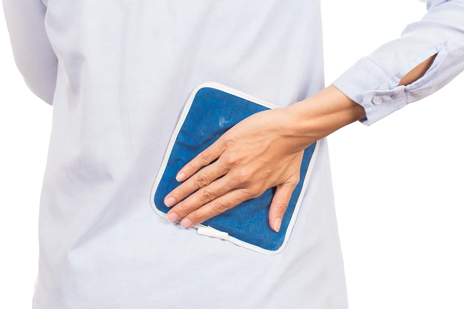 a woman applies ice pack for tailbone pain relief