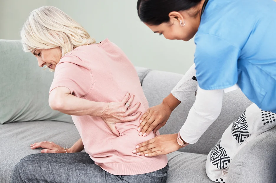 a doctor checks patient's lower back
