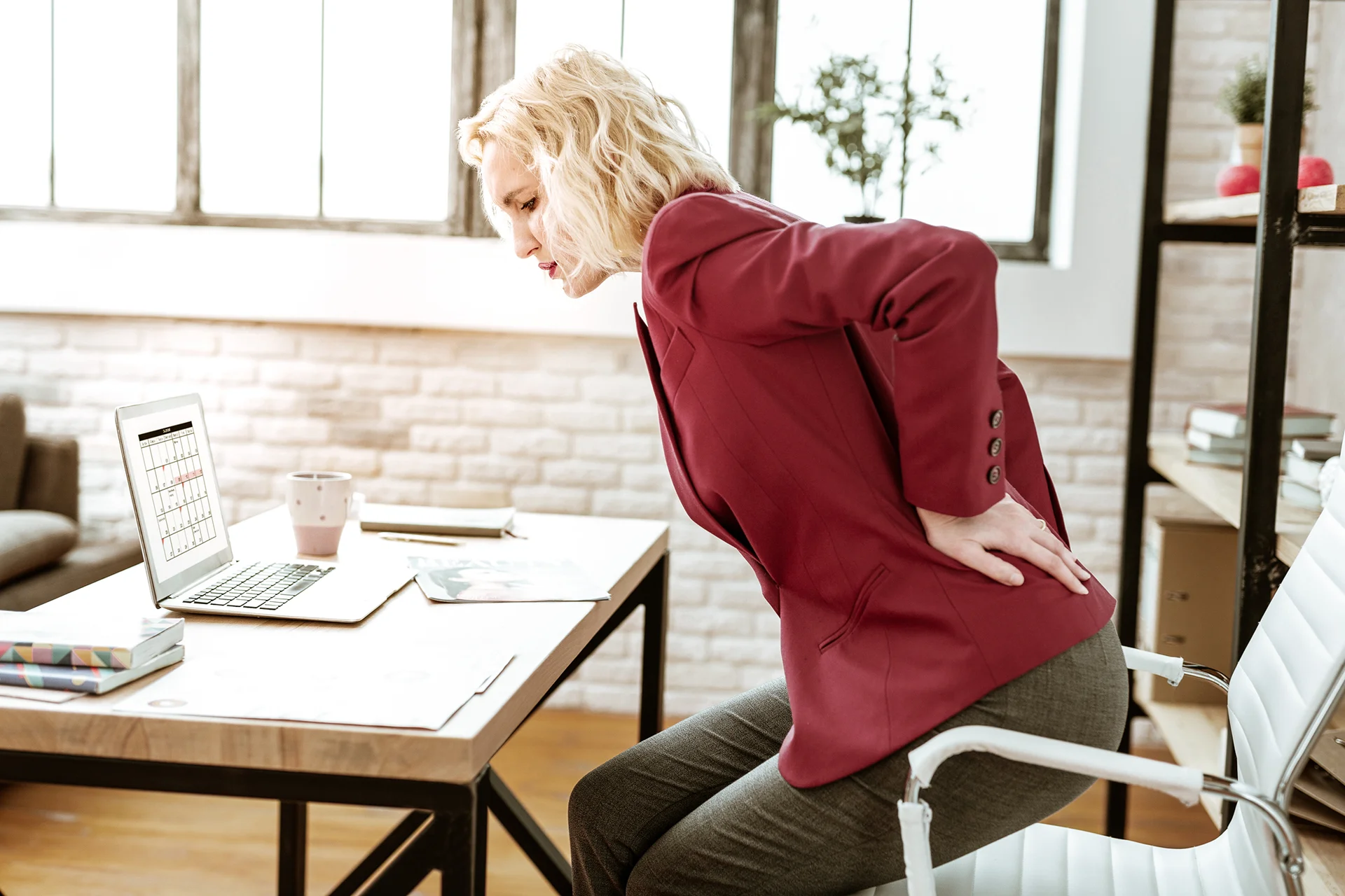 a woman suffering from lower back pain when bending over