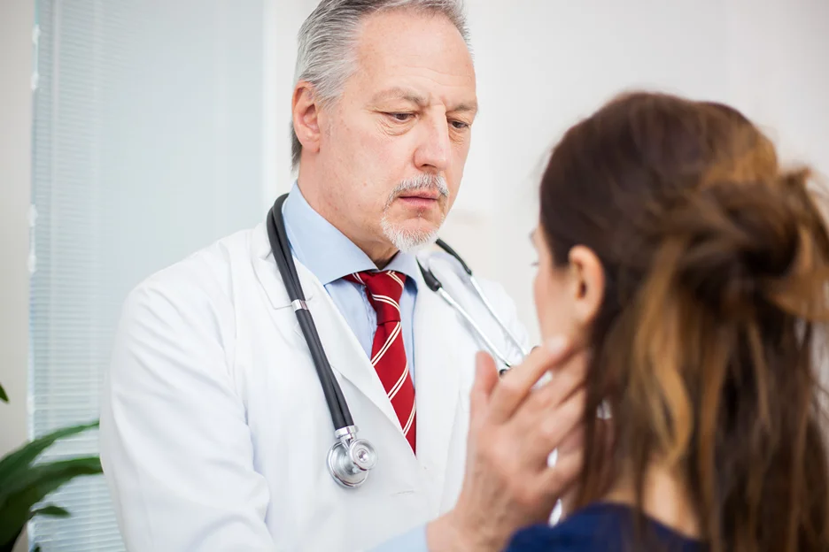 a doctor examines the neck anatomy of the patient