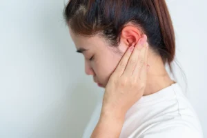 a woman suffers ear and neck pain