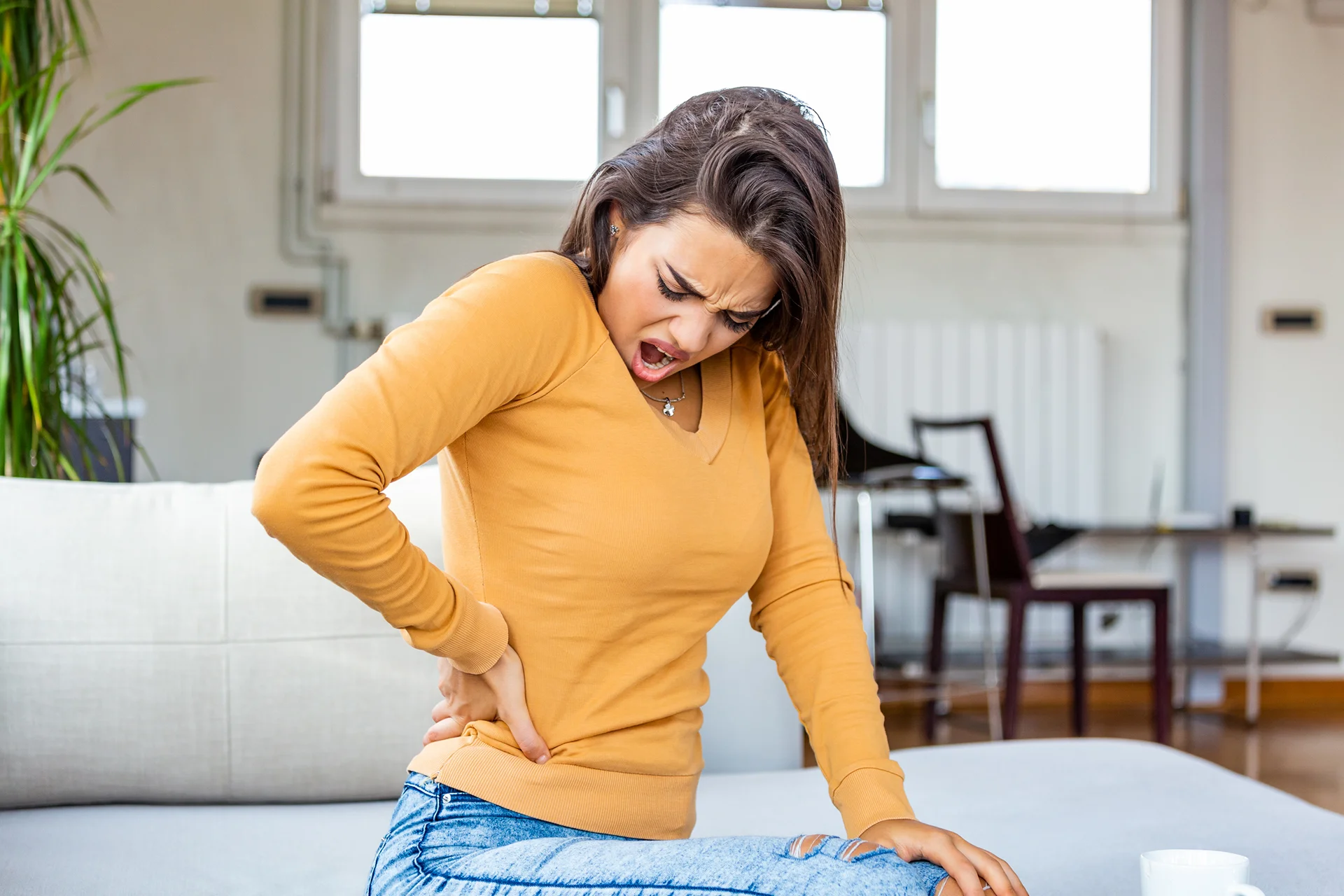 a woman suffers back pain related to kidney infection symptoms