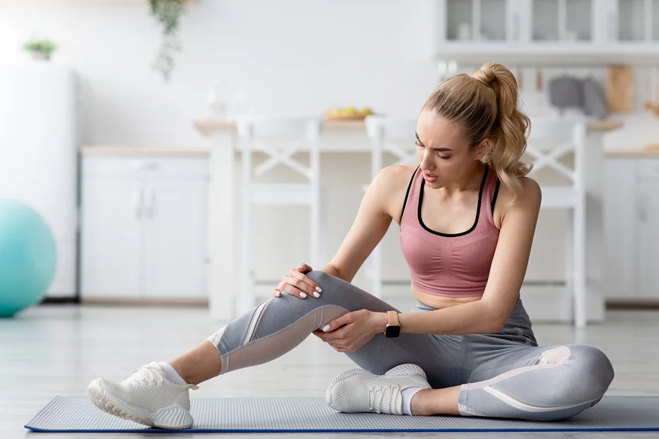 a woman suffering from low back pain that radiates down both legs