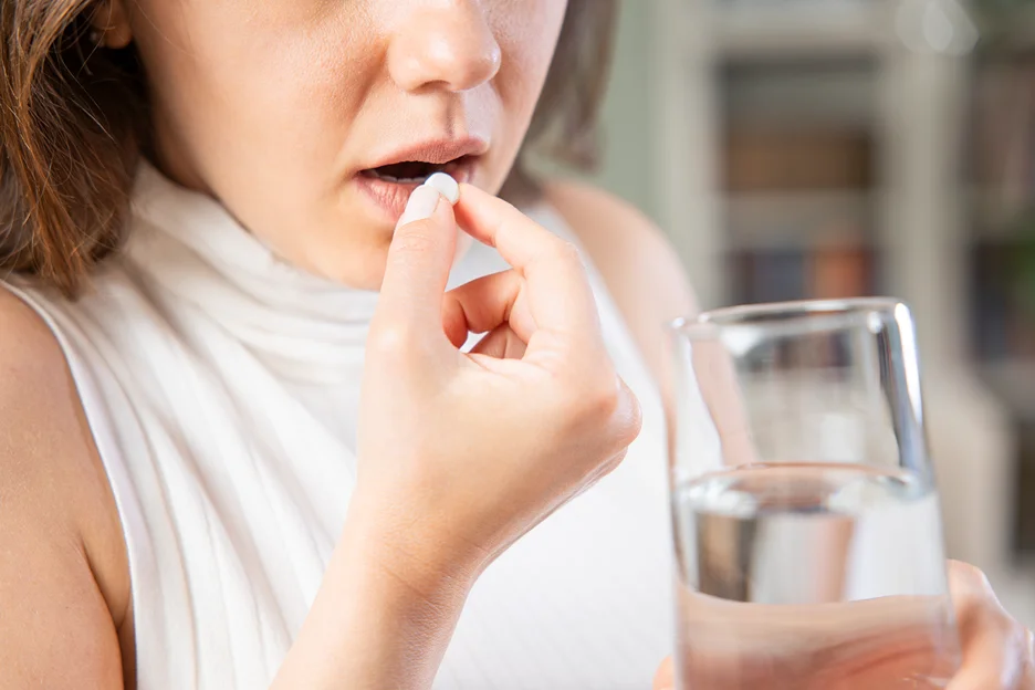 a woman taking pill for sciatica