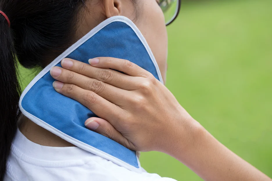 a woman applies cold therapy for neck pain 