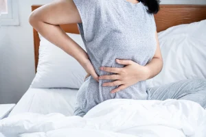 a woman suffering from low back pain after sleeping