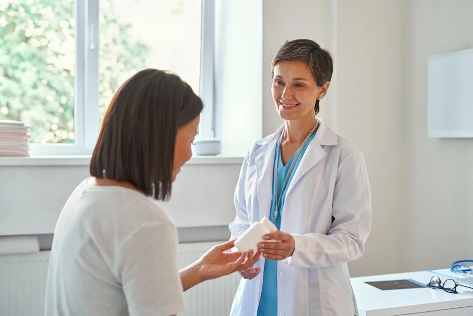 doctor gives prescription to her patient for back pain relief