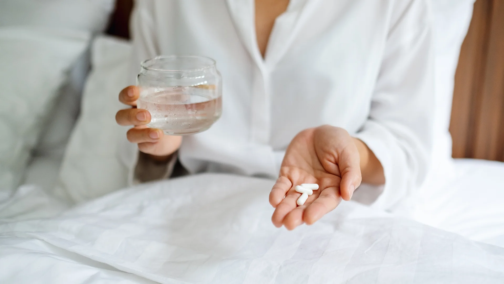 a sick woman taking pills for back pain relief