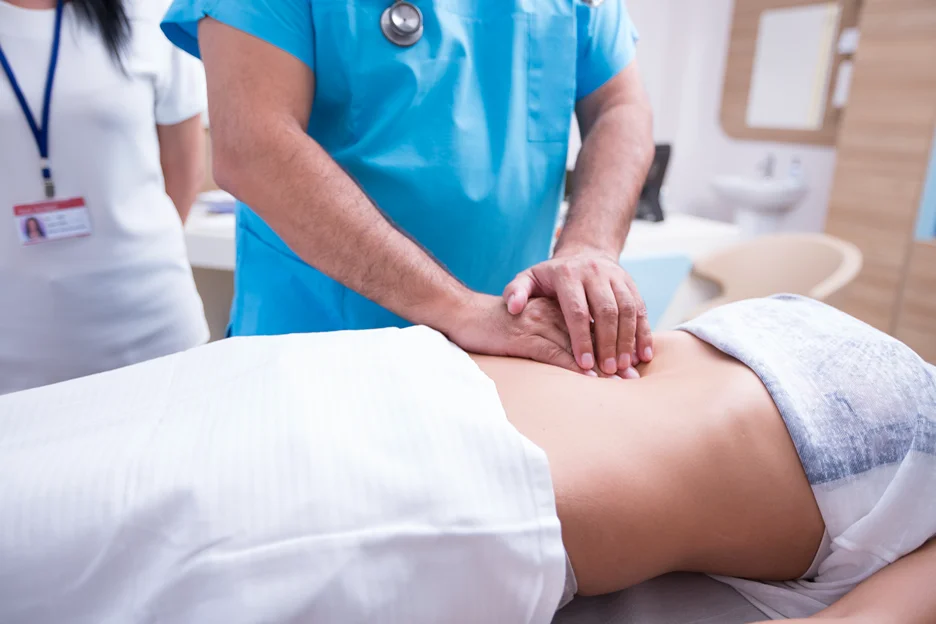 a doctor examines patient for appendicitis evaluation