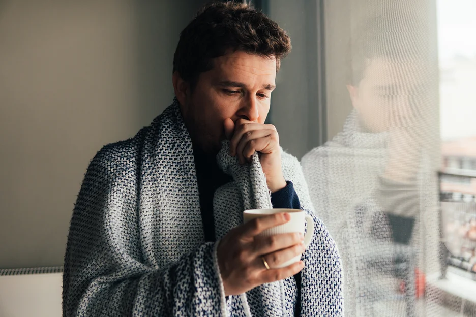 a man drinks hot beverage to find relief from cough