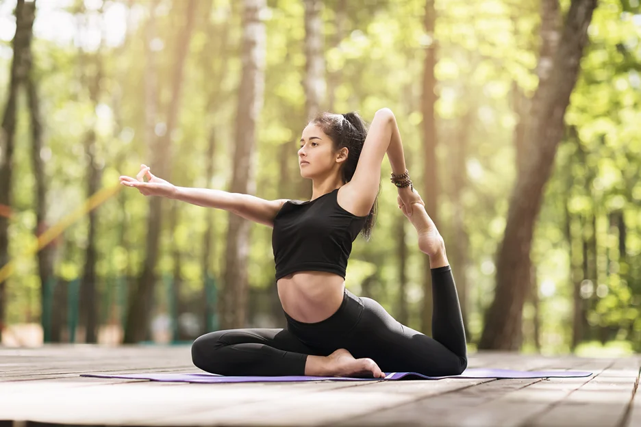 a portrait of a young woman practicing yoga outdoor