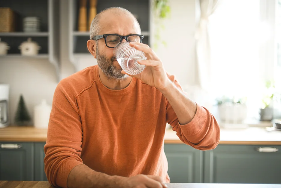 a man drinking water to prevent sciatica