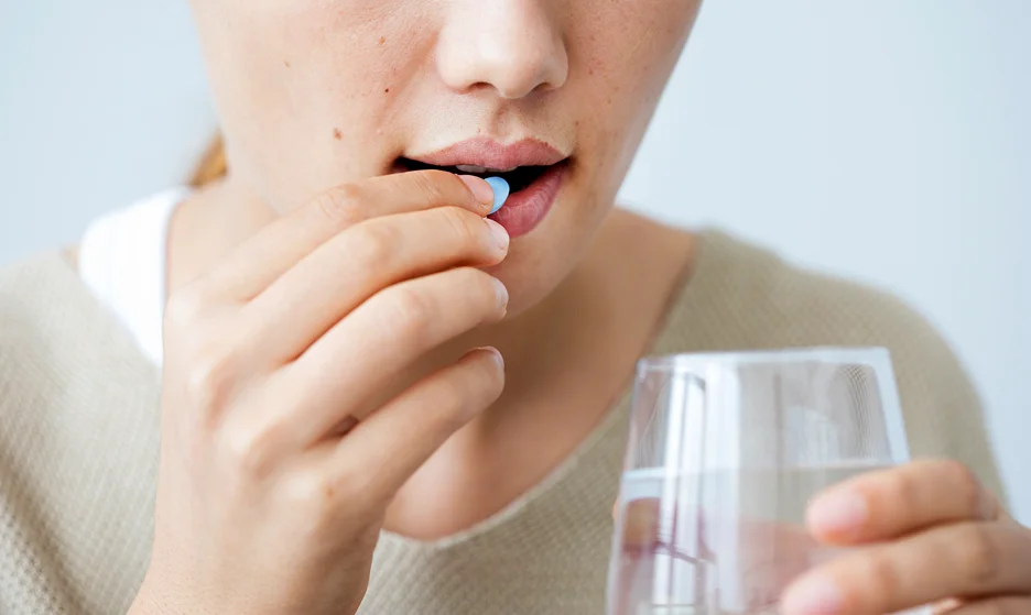 a woman taking a pill for disc neck pain