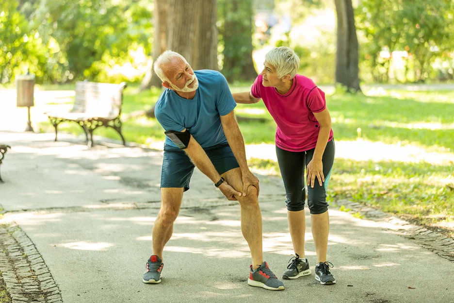 a senior man suffering from sciatica pain while a woman accompany him 