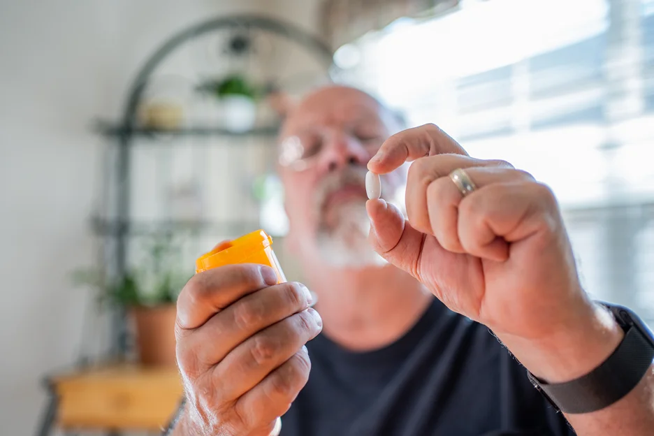 a senior man examining medication for sciatica and fibromyalgia